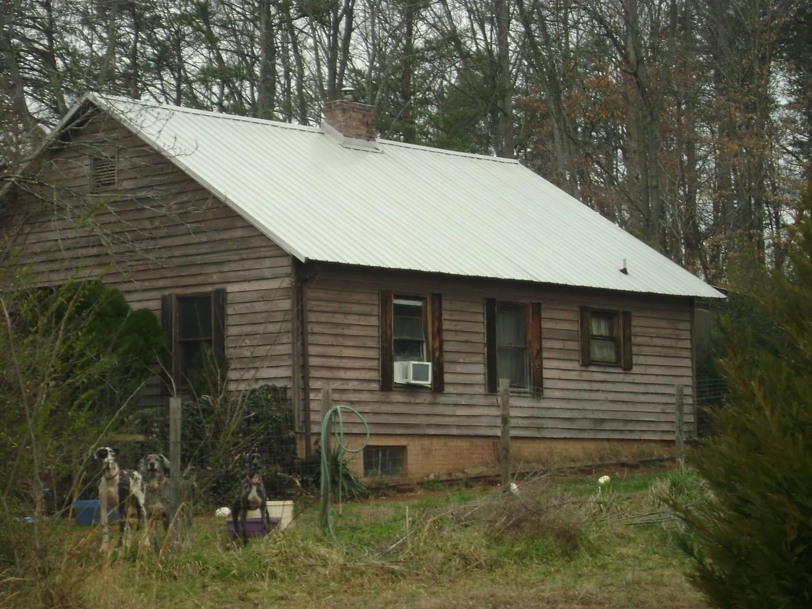 White metal roof on an old wood sided farmhouse, from a Metal Roof Installation job in Pella